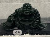 a black statue of a buddha sitting on a black platform