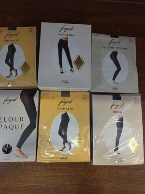 quatre paires de leggings sont posées sur une table en bois