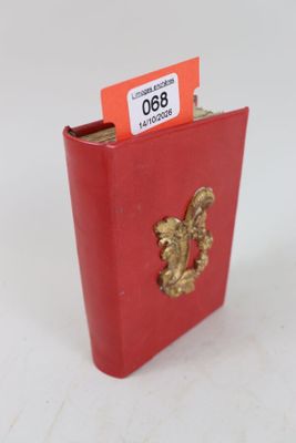 un petit livre rouge orné d'un lion doré