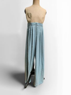 un pantalon bleu sur un mannequin, posé sur un fond blanc