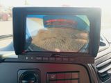 a car dashboard with a monitor showing a picture of a tractor
