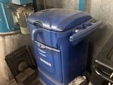 une poubelle bleue posée à côté d'une poubelle noire