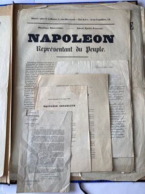 un livre ouvert posé sur une table recouverte de papiers