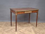 une petite table munie d'un tiroir, posée sur un parquet