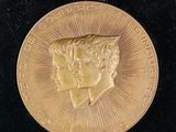 a close up of a gold medal on a black surface