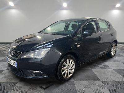 une voiture noire est garée sur le sol en damier d'un garage