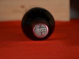 a bottle of wine sitting on a red cloth