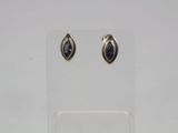 a pair of earrings with blue stones on a clear stand