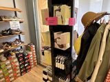 un présentoir de vêtements dans un magasin, surmonté d'un chapeau
