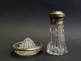 un ensemble sel et poivre en argent et en verre posé à côté d'un bol