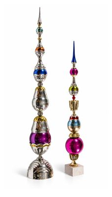three different colored ornaments are displayed on a white surface