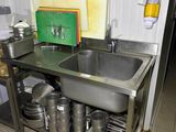 a kitchen with a sink and a lot of pots and pans on it