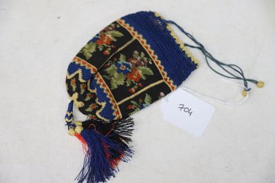 a small bag with a tassel on it on a white surface