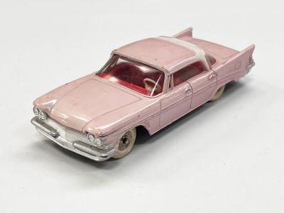 petite voiture rose posée sur une surface blanche, avec un fond blanc