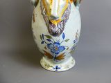 un vase orné d'une tête de lion sur fond gris