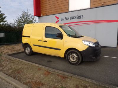 une petite camionnette jaune garée devant un immeuble