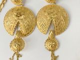 several pieces of gold jewelry are displayed on a white surface