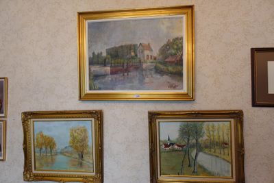 paintings hanging on the wall of a room with pictures on the wall