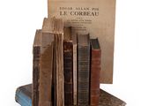 several old books are stacked on top of each other on a table