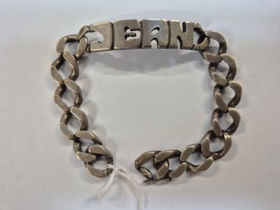 a close up of a metal bracelet with a chain on it
