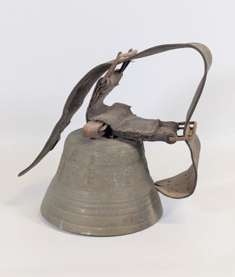 une cloche en métal surmontée d'un oiseau
