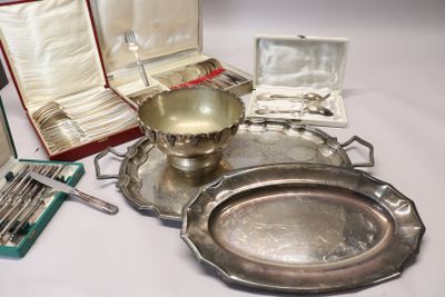 un plateau en argent et des couverts en argent posés sur une table blanche