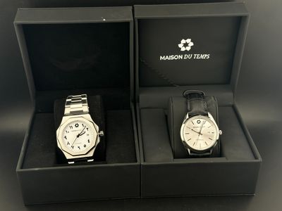 une paire de deux montres dans un coffret noir posées sur une surface noire