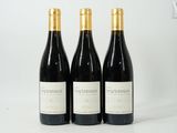 trois bouteilles de vin posées sur une table l'une à côté de l'autre