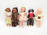 five dolls that are lined up on a white surface