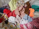a pile of clothes that is on a bed