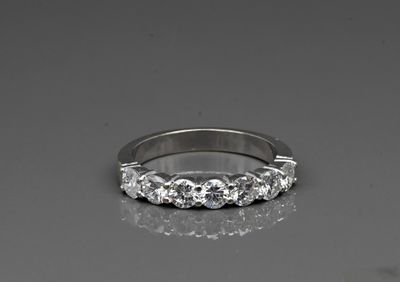 a close up of a diamond ring on a reflective surface
