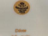a white plate with a gold emblem on it