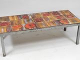 an image of a metal table with red flowers painted on it
