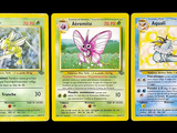 three pokemon cards with different designs on them on a black background
