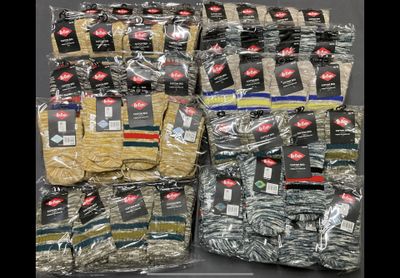 many bags of clothing that are sitting on a table