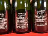 three bottles of wine are lined up on a table