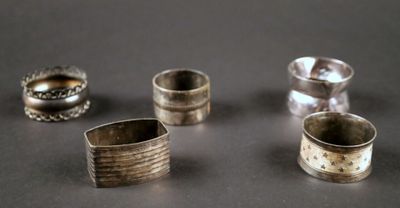several silver rings sitting on top of a table next to each other