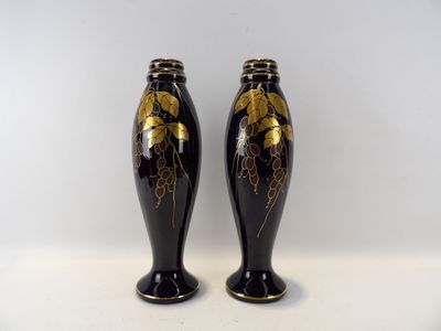 une paire de vases noirs et dorés sur fond blanc