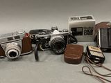 a lot of different types of cameras sitting on a table