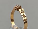 a close up of a gold ring with a diamond on it