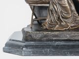a statue of a woman sitting at a desk
