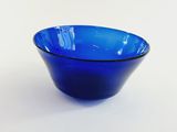 a blue glass bowl sitting on a white surface