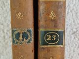 Deux vieux livres sont posés sur une table blanche