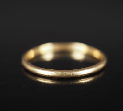 gros plan d'une bague en or sur une surface noire