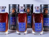 six bottles of whisky are lined up on a table