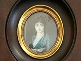 a picture of a woman in a blue dress in a gold frame
