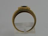 an image of a gold ring with a green stone in it