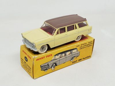 yellow toy car sitting on top of a box on a white surface