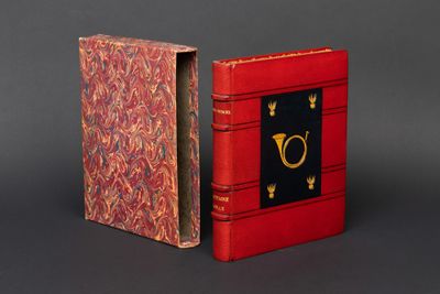 un livre rouge orné d'une lettre dorée et un livre rouge orné d'une lettre dorée
