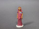 a small figurine of a woman in a pink dress